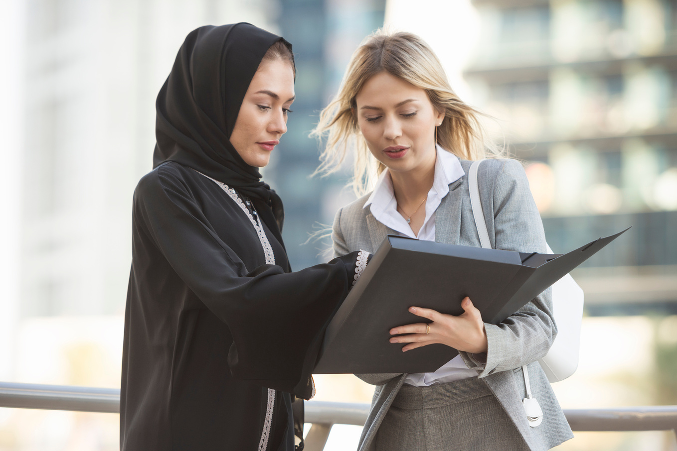 Women Discussing a Document in a Folder 
